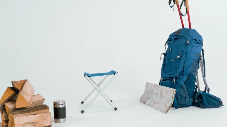 Un sac à dos de randonnée, des bâtons, un thermos et une carte dépliée